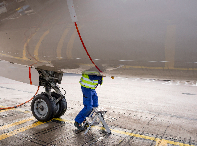 Ground crew inspecting aircraft landing gear