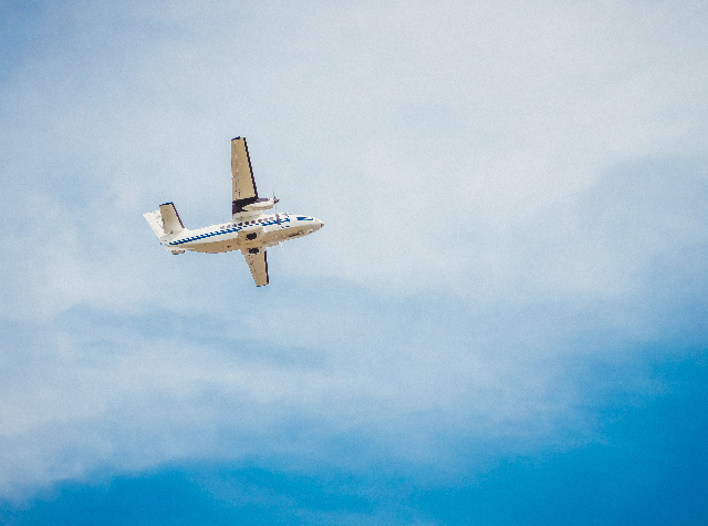 Small aircraft flying above clouds